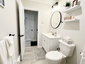 A bathroom with a toilet, sink, and mirror. There is a towel rack with a towel hanging on it. - Cozy Attitash Mtn Resort Condo with Full Amenities (Bartlett)