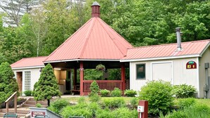 Un petit bâtiment avec un toit rouge, une véranda et une enseigne indiquant qu’il s’agit d’un centre de bien-être.
