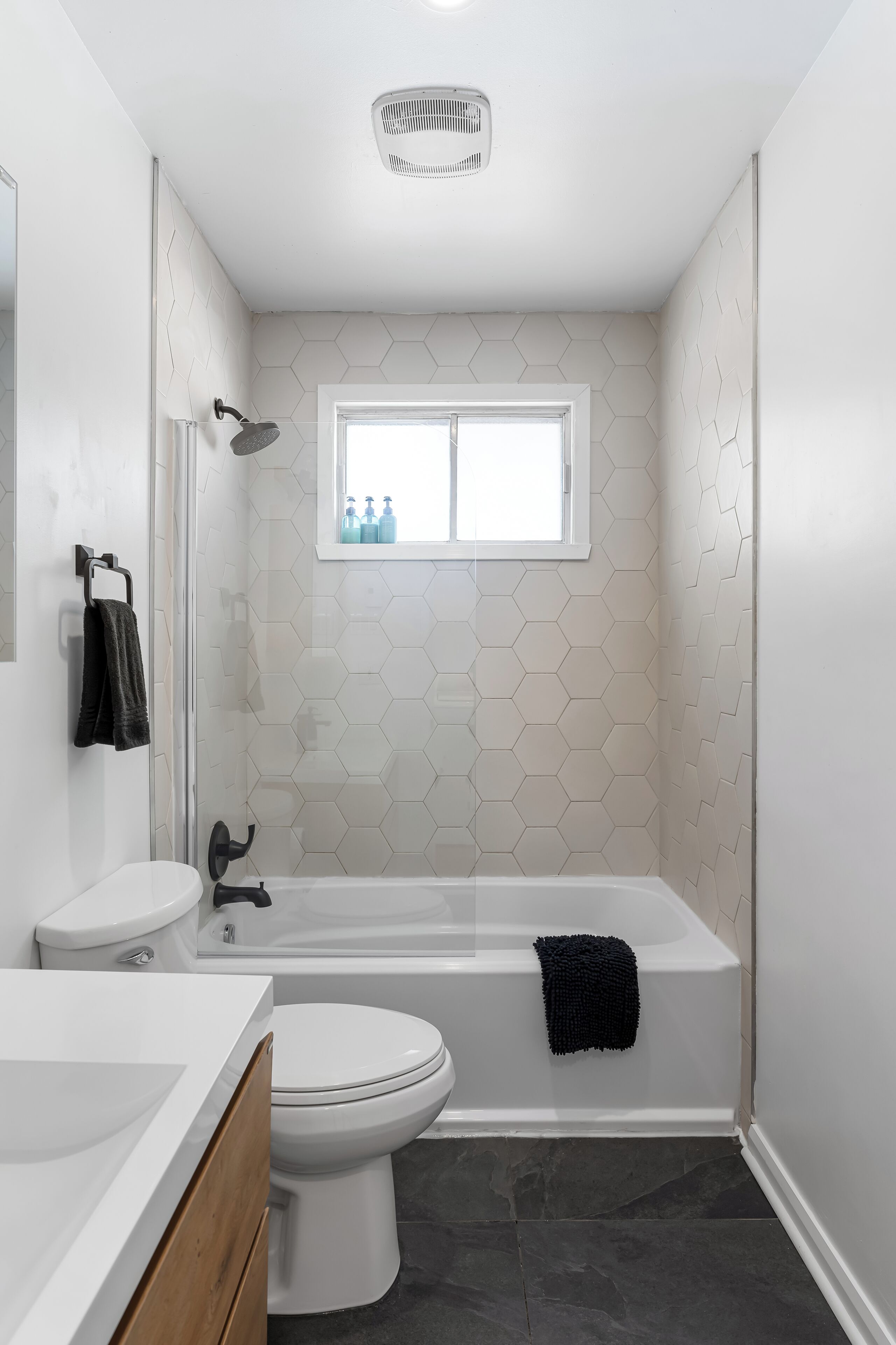 Une salle de bain moderne avec des toilettes blanches, une baignoire et une douche.
