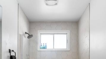 Une salle de bain moderne avec des toilettes blanches, une baignoire et une douche.