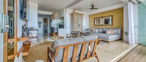 A spacious living area with a sofa, wooden furniture, and a large mirror.