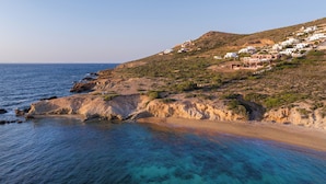 Un village côtier aux maisons blanches, situé sur une colline surplombant la mer.