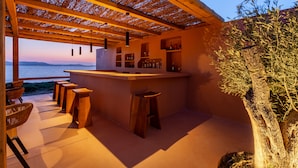 Un espace bar avec des meubles en bois et une vue sur la mer.