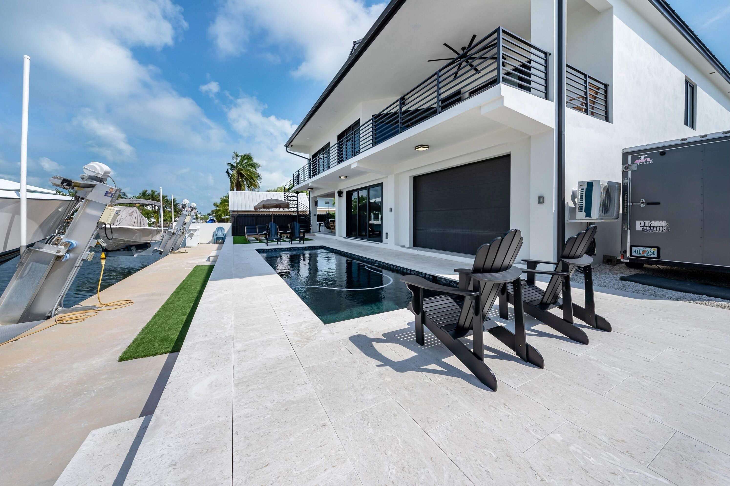 Ein modernes Haus mit Pool, Außenbereich und überdachter Terrasse.