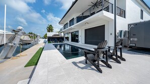 A modern house with a swimming pool, outdoor seating, and a covered area. - ISLAMORADA DREAM (Islamorada)