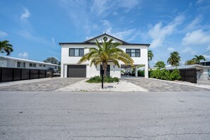 A modern two-story house with a garage, a palm tree in the driveway, and a clear blue sky. - ISLAMORADA DREAM (Islamorada)