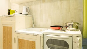 A compact kitchen with a white stove, a built-in oven, and a small countertop. - Mariet Athens Spa (Athens)