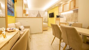 A modern hotel room with a dining area, a kitchen, and a living space. - Mariet Athens Spa (Athens)