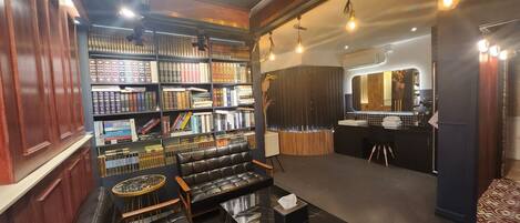 A library with bookshelves, a leather sofa, and a small table.