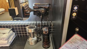 Une machine à café, une bouilloire et un présentoir à menus se trouvent dans un café.
