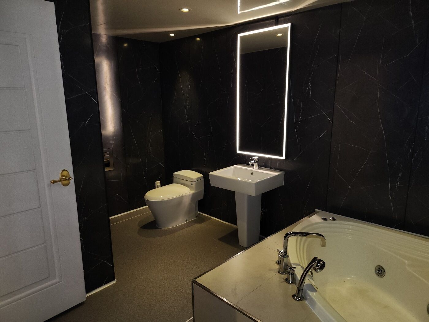 Une salle de bain moderne équipée de toilettes, d’un lavabo et d’une baignoire.