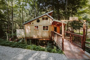A wooden cabin with a deck and a sign reading "Maple".