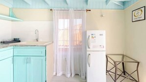 A kitchen with teal cabinets, a white refrigerator, and a glass table. - The cloud room At Csompo Silver Manor (Tower Isle)