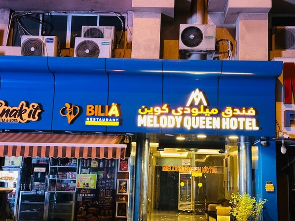 A hotel with a blue facade, a restaurant named 'Bilia' and a shop named 'Snakit'.