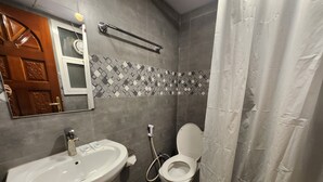 Un baño con lavamanos, inodoro y cortina de ducha.
