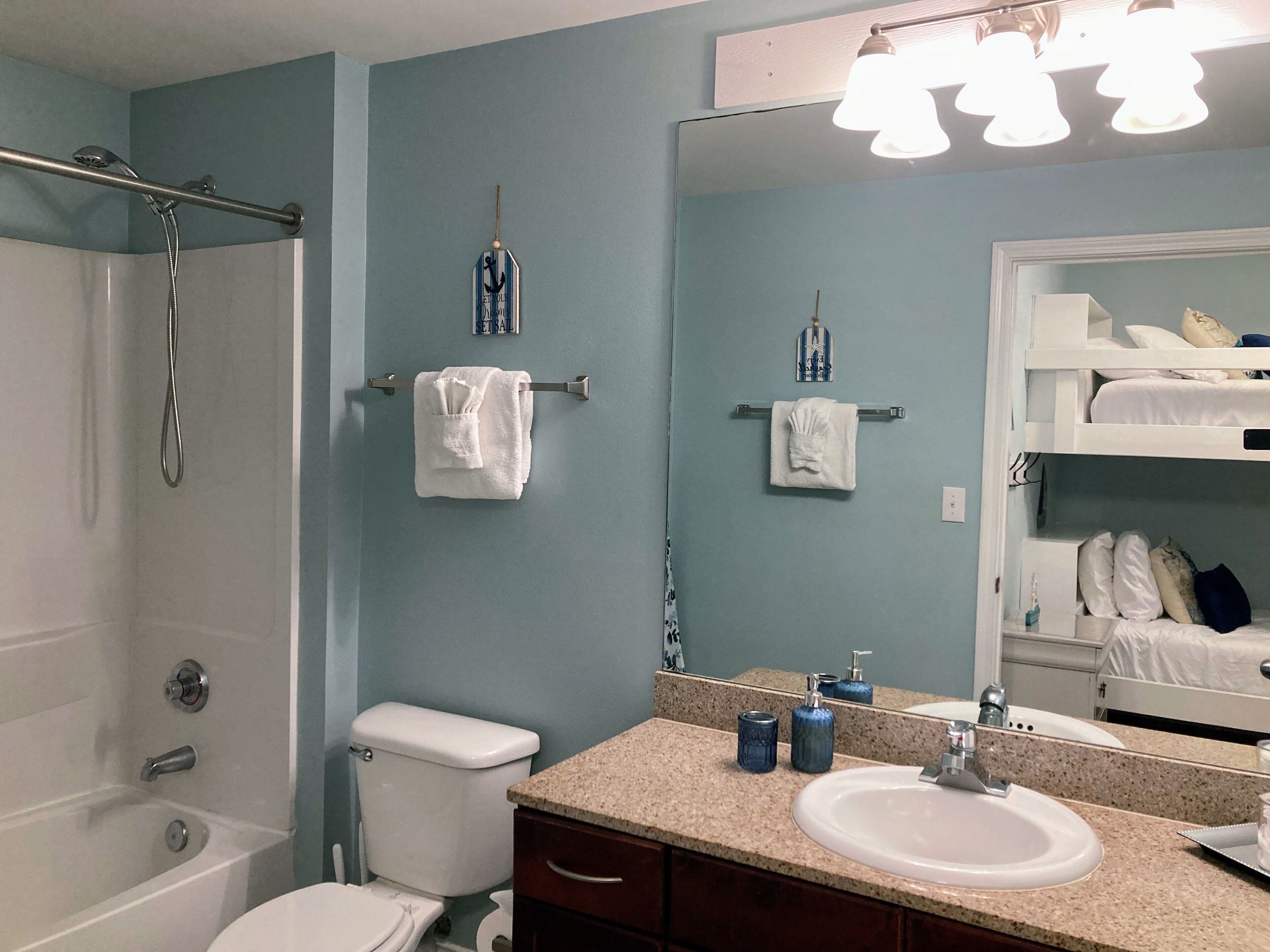 Une salle de bain avec une baignoire, des toilettes, un lavabo et un miroir.