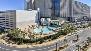 A large hotel with multiple floors, a central swimming pool, and a parking garage.