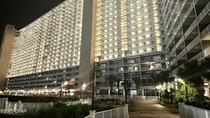 A high-rise hotel with multiple balconies and a well-lit facade.