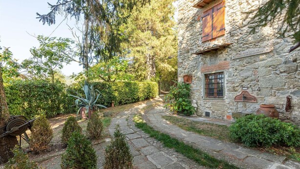 Un bâtiment en pierre avec un chemin en pierre menant à une porte en bois.