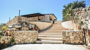A stone staircase leading to a house with a flat roof and a stone wall on one side. - Cozy home in Floridia (Floridia)