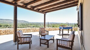 An outdoor patio with stone walls, wooden furniture, and a foosball table. - Cozy home in Floridia (Floridia)