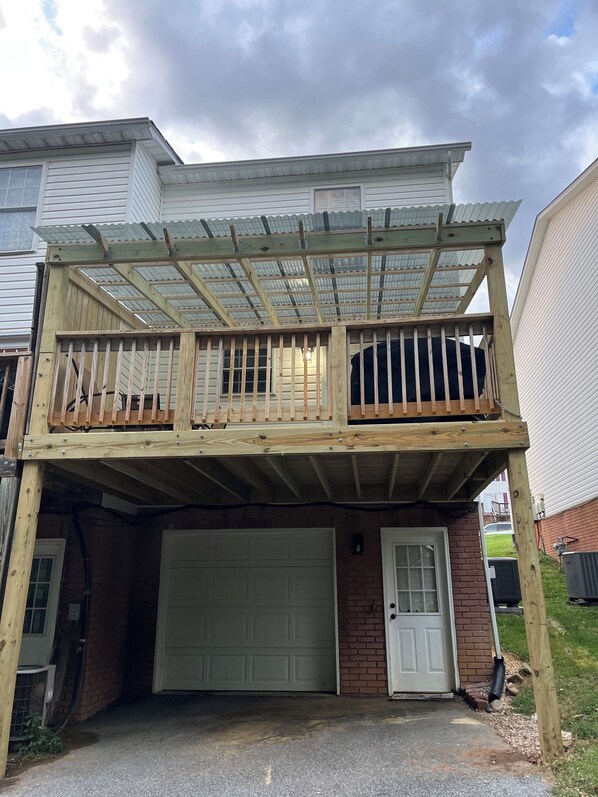 Une maison à deux étages dotée d’un balcon couvert et d’un garage.