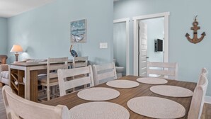 Een eethoek met een houten tafel en stoelen, een lamp en een schilderij aan de muur.