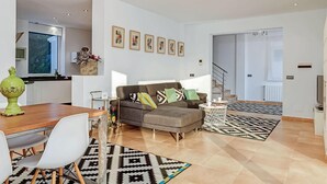 Una sala moderna con sofá, mesa de centro y alfombras estampadas.