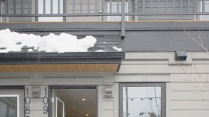 A residential building with a garage door, a front door, and a visible number '109'. - Enchanted Mountain Getaway: Accessible Retreat in Canmore, Close to Banff (Canmore)