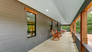 A covered porch with wooden flooring, built-in rocking chairs, and a view of a green landscape. - Sip, Fish & Relax Fireside: Serene Schulenburg Gem (Schulenburg)