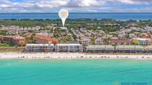 Eine Küstenstadt mit Hotels direkt am Strand, einem Schild mit einer Schildkröte als Hinweis auf eine Sehenswürdigkeit in der Nähe und freiem Blick auf den Ozean.