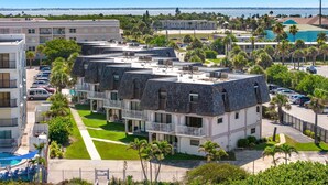 Un hotel a più piani con piscina, area salotto esterna e vista sull'oceano.