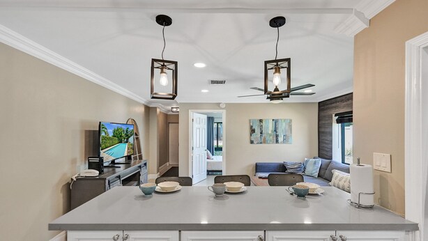 A modern kitchen with a central island, pendant lighting, and a ceiling fan. - Tranquil Getaway w/ Private Heated Pool (Fort Lauderdale)