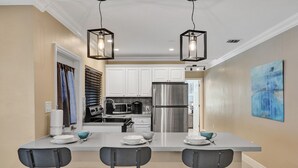 A modern kitchen with white cabinets, stainless steel appliances, and a central island with bar stools. - Tranquil Getaway w/ Private Heated Pool (Fort Lauderdale)