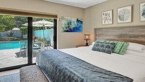 A bedroom with a large bed, a view of a swimming pool, and artwork on the walls. - Tranquil Getaway w/ Private Heated Pool (Fort Lauderdale)