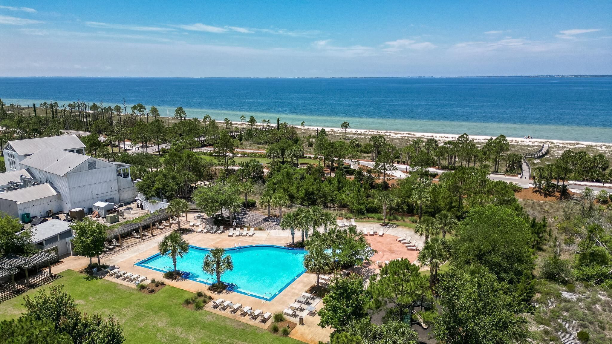 A resort with a swimming pool, beach, and ocean view.