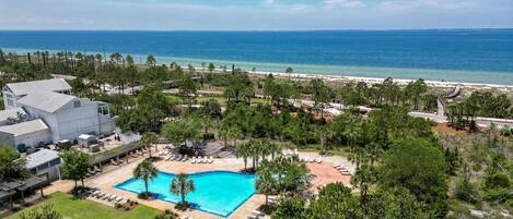 A resort with a swimming pool, beach, and ocean view.