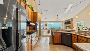 Una cocina moderna con electrodomésticos de acero inoxidable, armarios de madera y una isla grande.