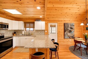 A kitchen with a granite countertop, white cabinets, and a wooden ceiling. - Beautiful Lodge in The Hideout!! (Lake Ariel)