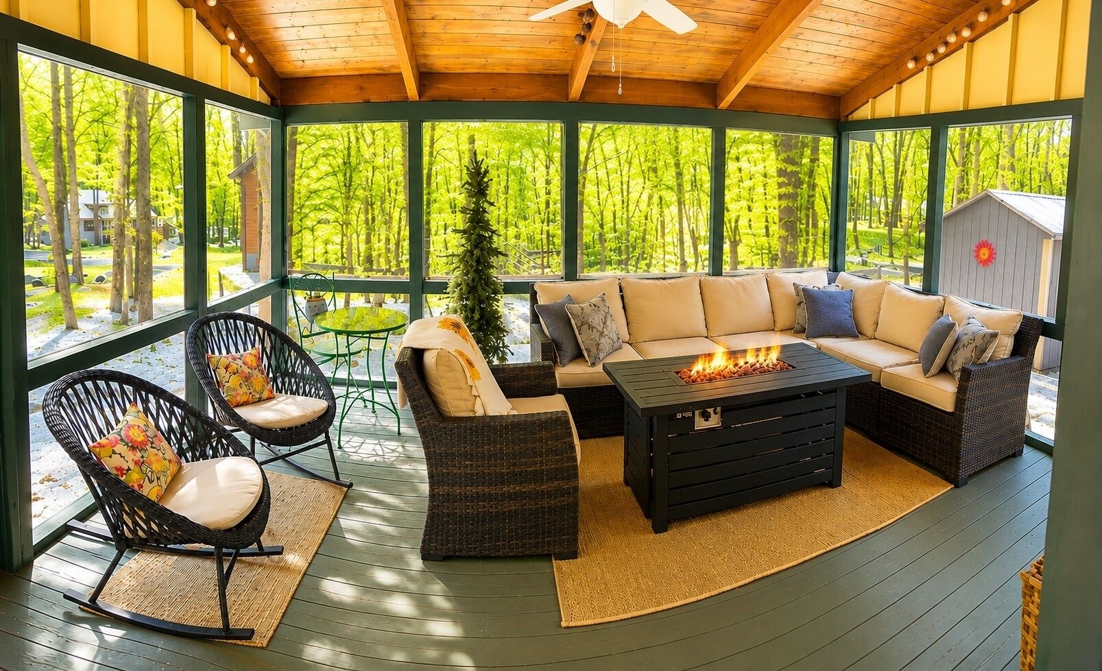 Un espace extérieur aménagé avec des meubles en osier, une table avec foyer intégré et une vue sur une forêt.
