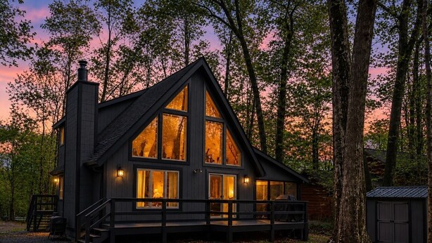 A cabin with a large deck, a fire pit, and a chimney. - Beautiful Lodge in The Hideout!! (Lake Ariel)