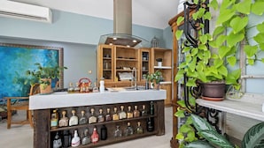 Una cocina con encimera de mármol, armarios de madera y una variedad de botellas.