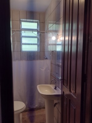 A bathroom with a toilet, sink, and shower area. - Casa Rústica de Santa Teresa (Santa Teresa Rio de Janeiro)