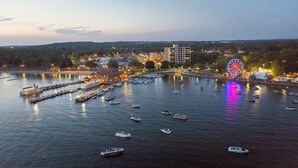 A waterfront marina with boats docked, a Ferris wheel, and buildings in the background. - Luxury Property-Walk to lake and downtown Lake Geneva. Pet Friendly, Sleeps 8 (Lake Geneva)