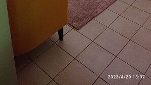 Une chambre à coucher avec un lit, une table de chevet, une chaise et une fenêtre avec des rideaux.