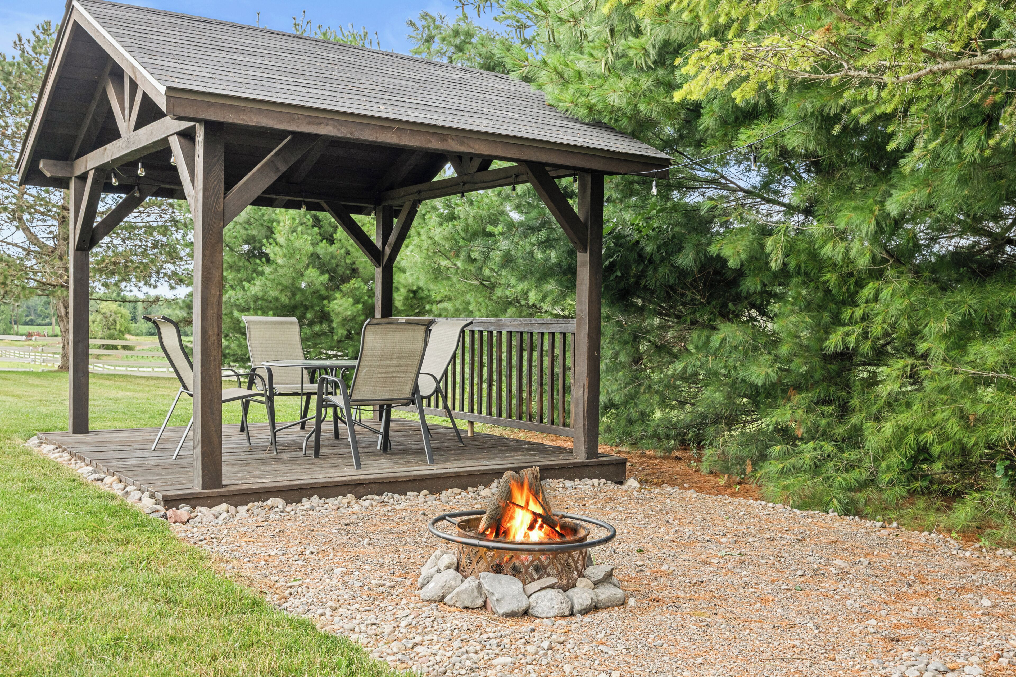 A covered outdoor seating area with a fire pit.