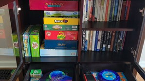 Ein Bücherregal mit verschiedenen Gesellschaftsspielen und Büchern.
