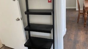 A black metal shelving unit with a thermostat on the top shelf. - Irvington Apartment (Irvington)
