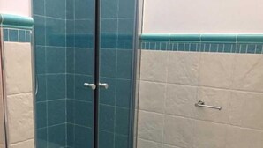 Une salle de bain avec une douche à parois de verre, des toilettes et un lavabo.