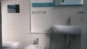 Une salle de bain comprenant des toilettes, un bidet et un lavabo.